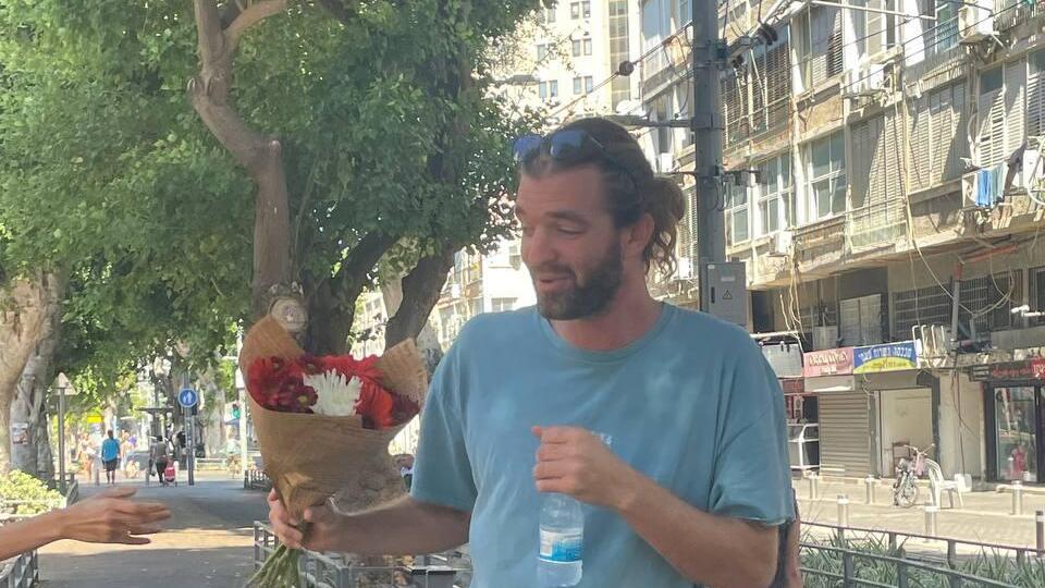 לב קרייטמן בזירת הפיגוע (צילום: ליאור אוחנה) לב קרייטמן שירה באחד המחבלים בפיגוע ביפו, שם פרחים בזירה