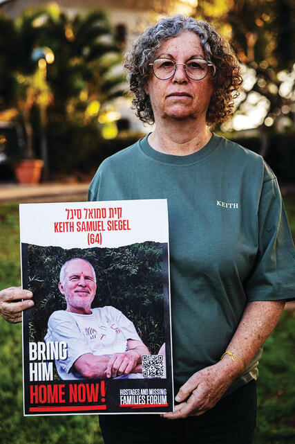 אביבה סיגל אוחזת בתמונתו של בעלה | צילום: אופיר טל yk14104961