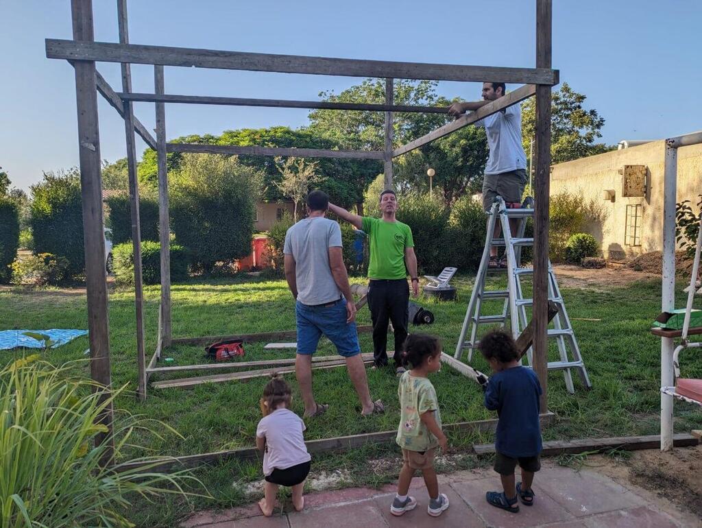 Tal Chaimi and his family erecting a sukkah (Photo: Courtesy of the family) טל חיימי ז"ל עם משפחתו בחג שעבר