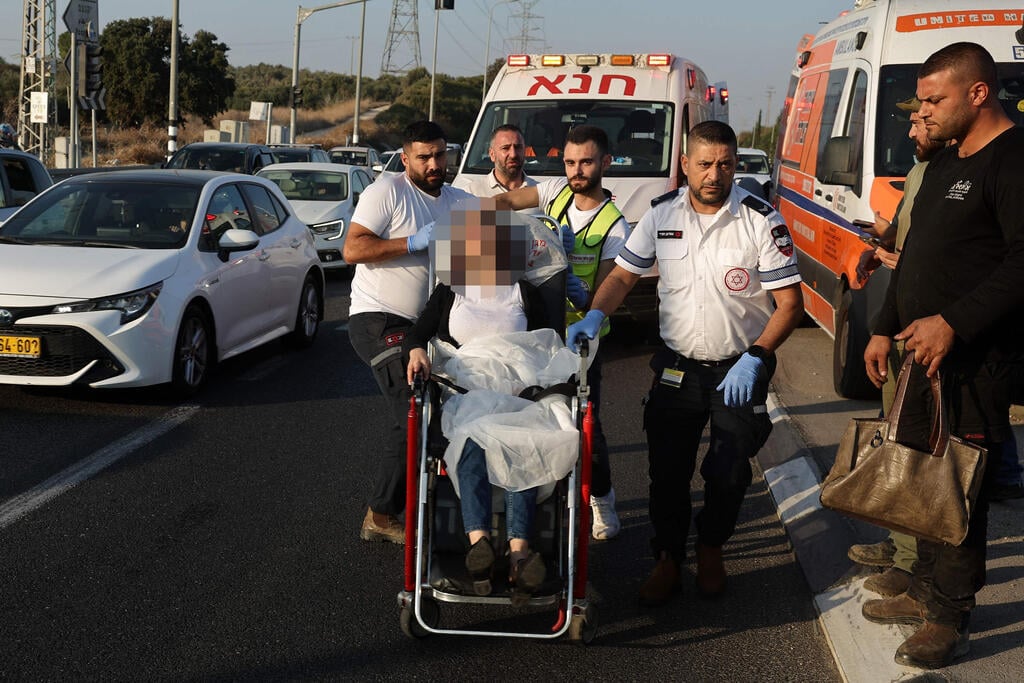 Hezbollah rockets kill 2 wound others north of Haifa (צילום: Ahmad Gharbali / AFP) פינוי פצועים ליד קריית אתא