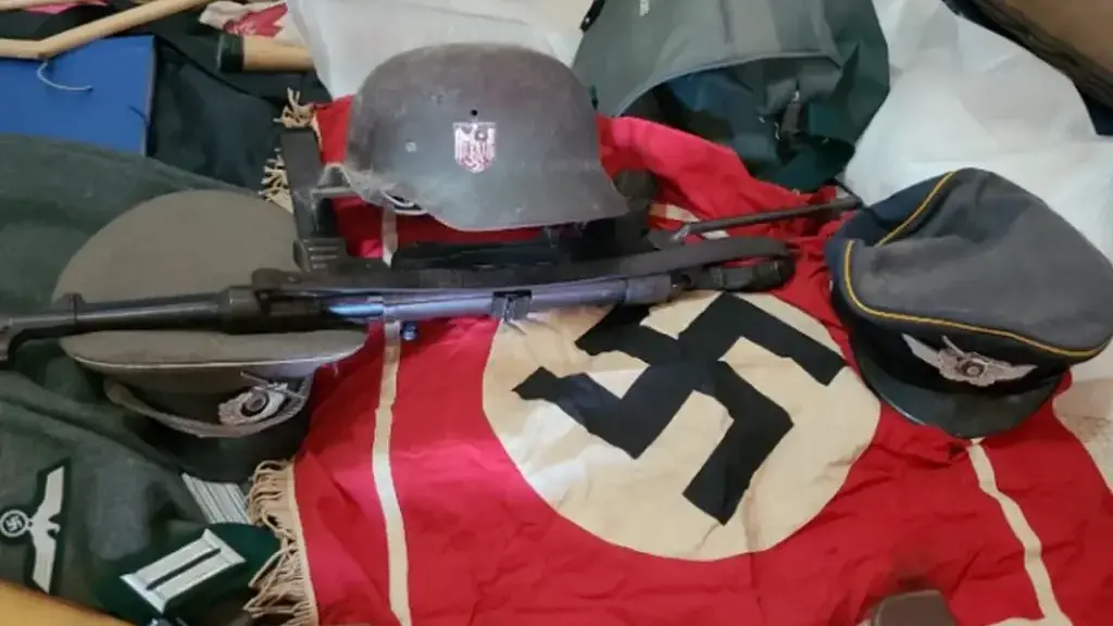 Nazi memorabilia found in the suspect's home (Photo: Argentine Defense Ministry) דגל נאצי, רובה וקסדות שנמצאו בבית