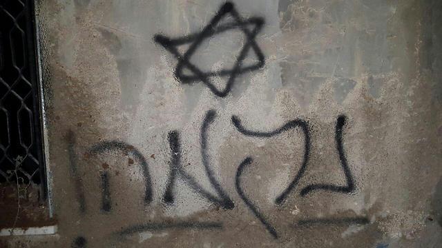 The word 'revenge' sprayed on the wall of Mamoun Dawabsheh's home (Photo: Rabbis for Human Rights)