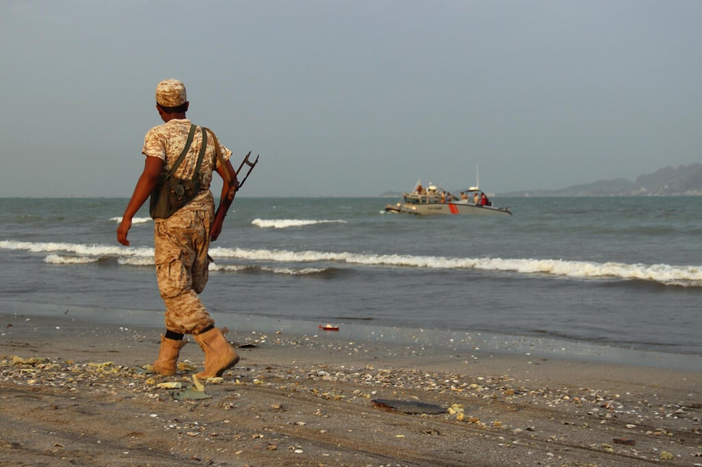 A soldier with the Yemeni government forces stands on a beach in Aden, Yemen 