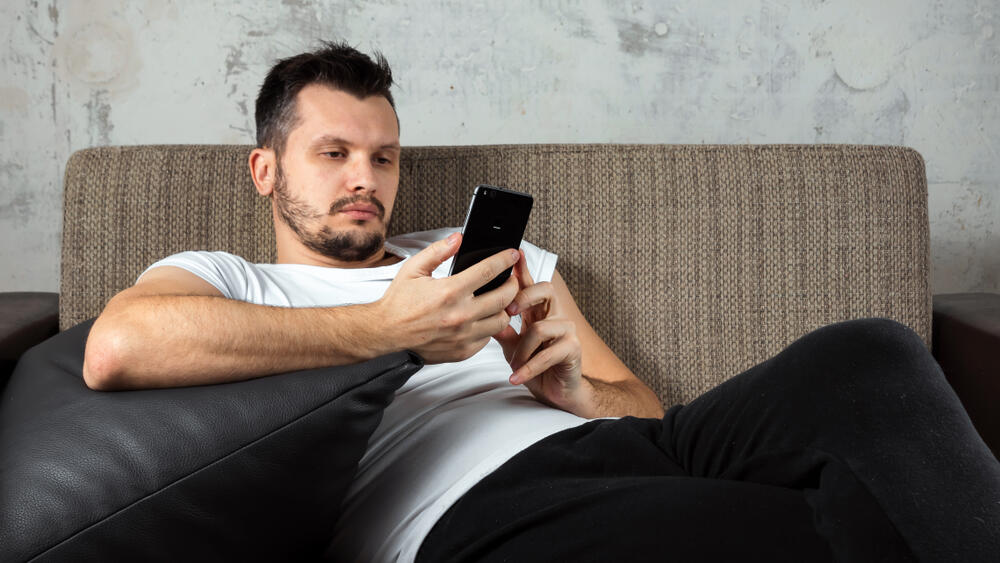 לא סימן לאדישות אלא משקפת עומס רגשות (צילום: shutterstock) בחור מתעסק בטלפון הסלולרי במקום ללכת לישון