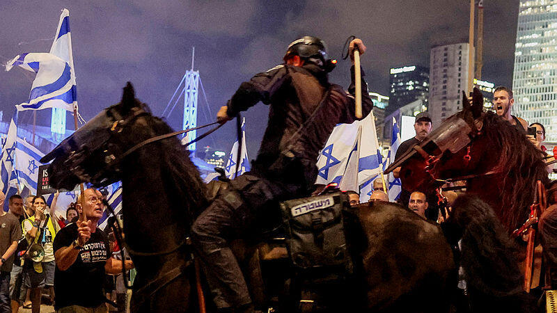 פרש משטרתי מניף אלה על מפגין בתל אביב, יולי 2023 (צילום: REUTERS/Nir Elias) פרש משטרה מכה מפגין במחאה באיילון
