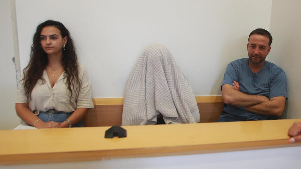 השוטר אביה סטמאקר מסתיר את פניו בבית המשפט (צילום: רועי עידן) אור בן שאנן מייצגת את אביה סטמקאר