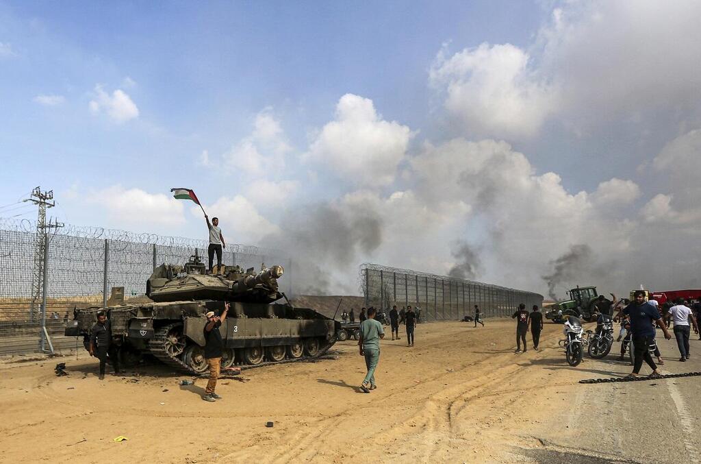 Gazans cross the fence on October 7 (Photo: AP) פריצת הגדר בגבול עזה
