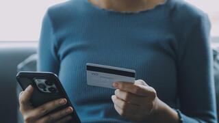 אישה עם טלפון וכרטיס אשראי