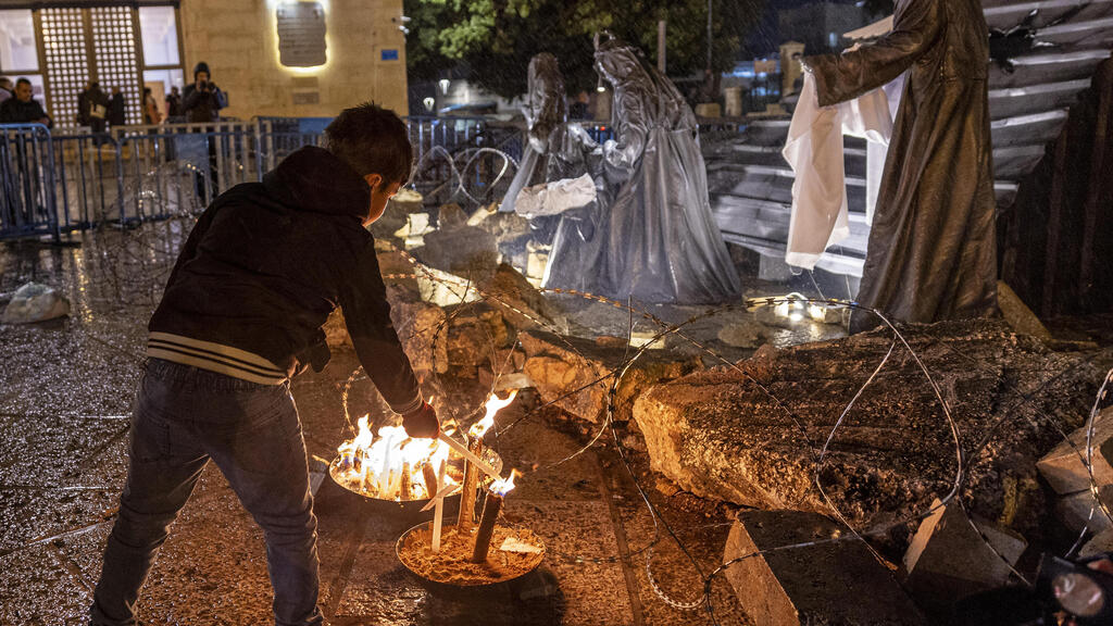 Lighting candles in front of church in Bethlehem (Photo: Maja Hitij/Getty Image) בית לחם