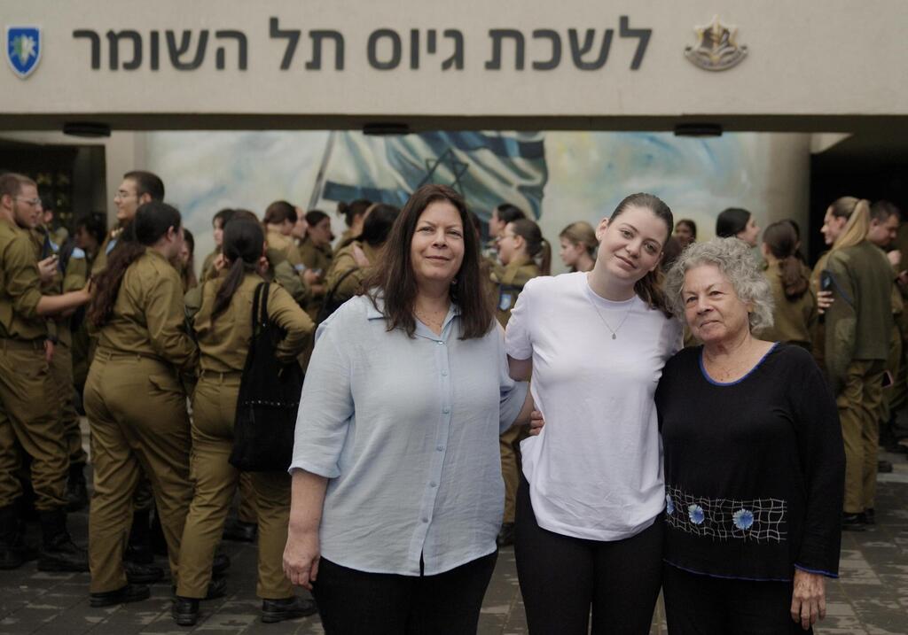 Noga Weiss, center, on the day of her enlistment in the IDF, while her father was still being held in Gaza (Photo: IDF) נגה וויס ואמה בלשכת הגיוס