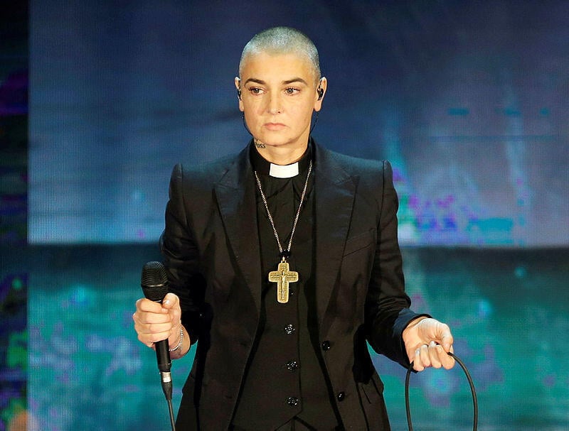 ביקשה להיקבר לבושה בגדי כומר, כשלצידה ספר תנ"ך בעברית ואלבומה Theology (צילום: AP Photo/Antonio Calanni) שינייד אוקונור כפי שצולמה בתוכנית טלוויזיה במילנו, 2014