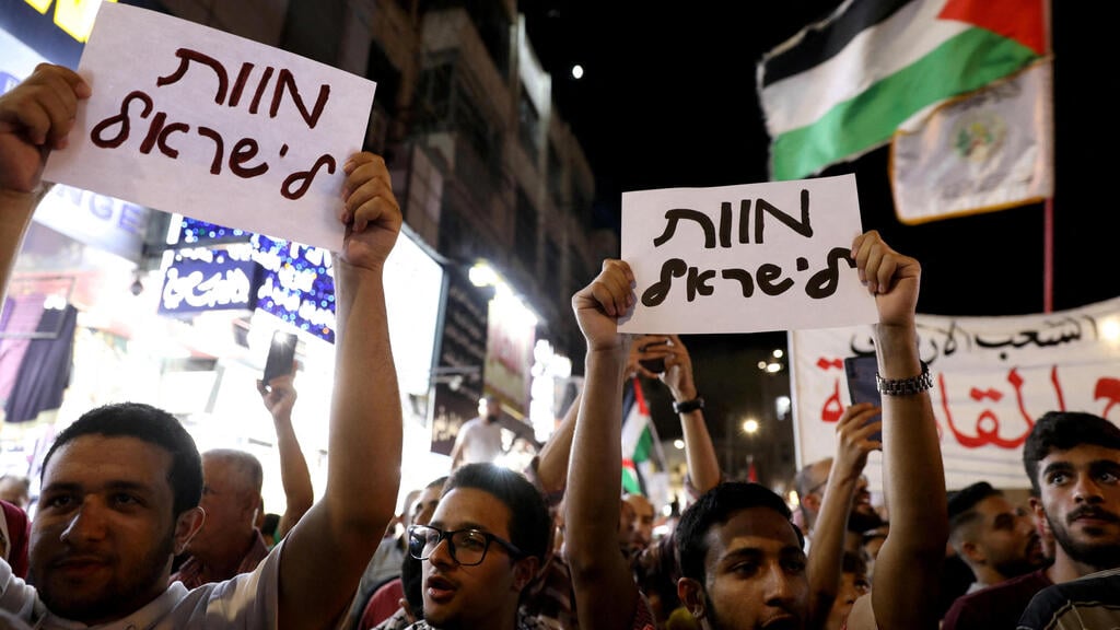Jordanian protesters hold up signs reading 'death to Israel' (Photo: Alaa Al Sukhni / Reuters) שלטי "מוות לישראל" בחגיגות הפיגוע בעמאן, ירדן