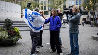 אדם עם דגל ישראל מתראיין לתקשורת הולנדית