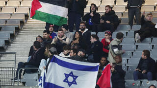 דגל פלסטין ודגל ישראל באותו יציע במשחק של נבחרת ישראל נגד נבחרת צרפת