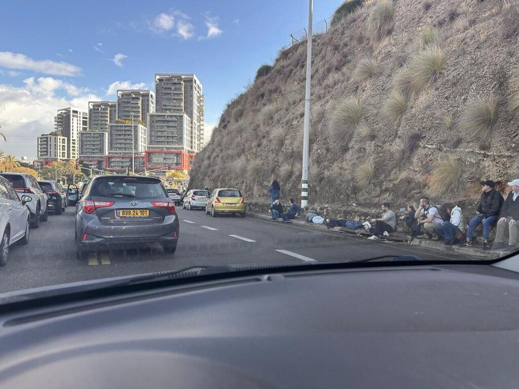 נשכבים על הכביש באזור הרצליה בזמן האזעקות (צילום: חנן כהן) נשכבים על הריצפה באמצע הכביש באזור הרצליה בעקבות מטחים לשרון