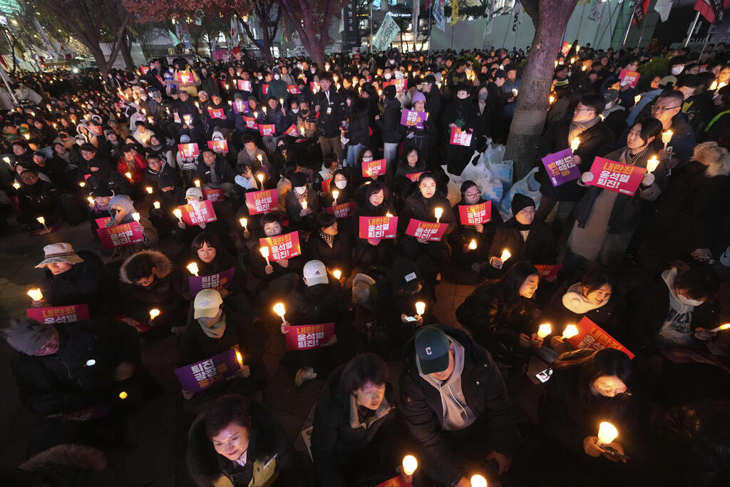 עם שלטים ונרות. המפגינים בסיאול (צילום: AP Photo/Lee Jin-man) מחאה ב סיאול דרום קוריאה בדרישה להתפטרות הנשיא יון סוק יאול