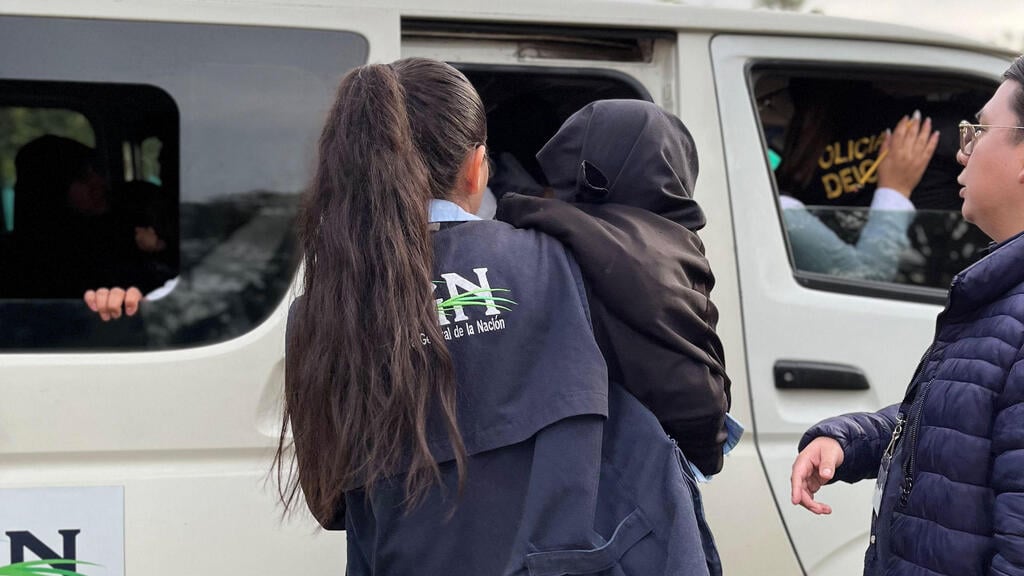 Children are rescued from the Lev Tahor cult compound (Photo: Guatemalan Attorney General of the Nation's Office \ AFP) אשת כוחות הביטחון מחלצת את אחד הילדים
