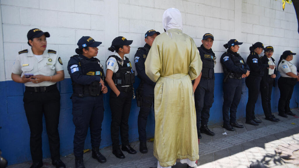 Guatemalan police forces with a sect member (Photo: REUTERS/Cristina Chiquin) אחד מאנשי הכת מול השוטרים