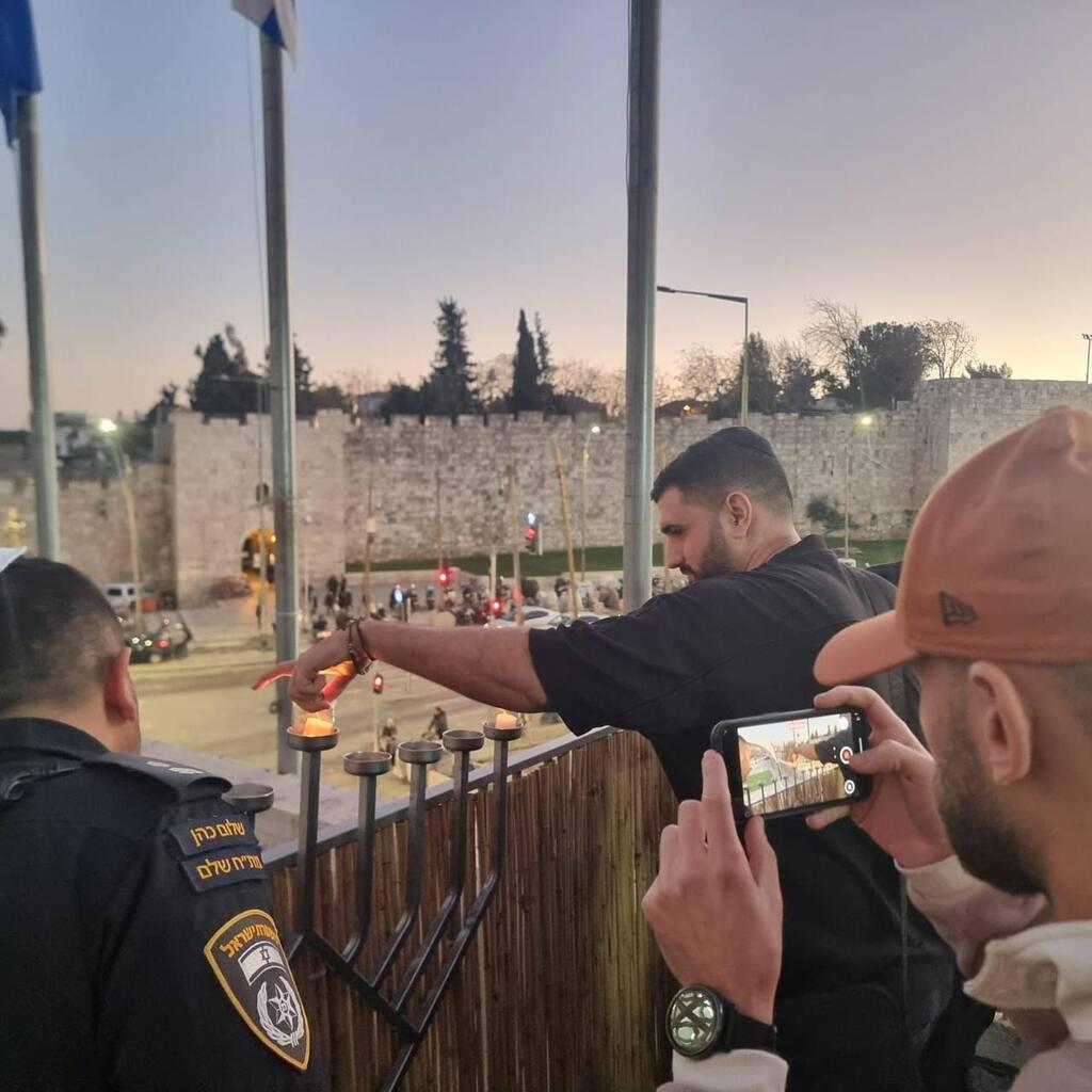 Injured policeman Ofir Hagbi lights a candle (Photo: Police Spokesperson's Unit) השוטר רס"ם אופיר חג'בי מדליק נר חנוכה