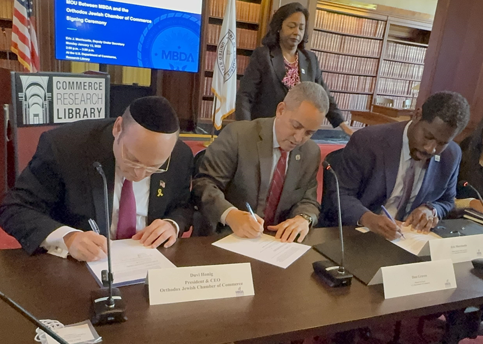 Duvi Honig (left) sign the Memorandum of Understanding unlocking billions in funding for Jewish-owned businesses (Photo: Orthodox Jewish Chamber of Commerce) L-R: Honig, Graves, Morissette and Madiha sign the Memorandum of Understanding