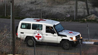 כלי רכב של הצלב האדום נעים לאורך שטח כלא עופר במערב רמאללה