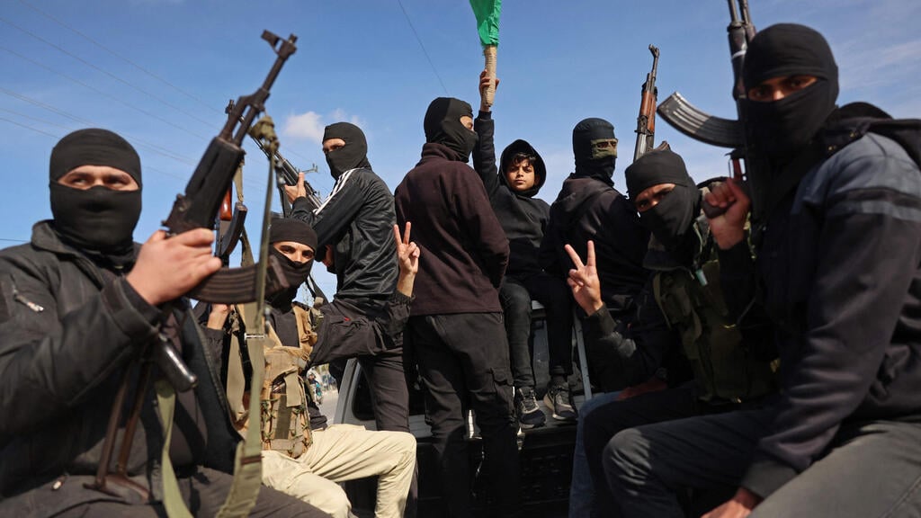 Hamas terrorists celebrate the cease-fire in Gaza (Photo: Bashar Taleb / AFP) מחבלים בדיר אל בלח