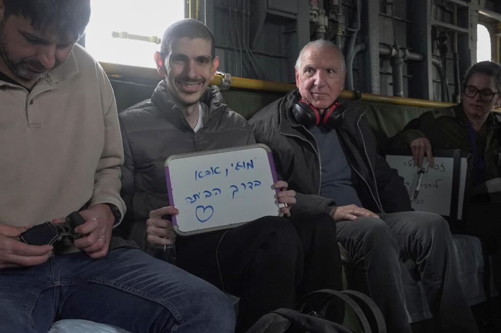 Levy airlifted to the hospital with his family, holds up a sign reading, 'Moggie, Daddy's coming home' (Photo: IDF) תיעודים מרגשים של אור לוי עם בני משפחתו במסוק בדרכם לבית החולים