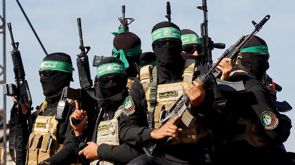 Hamas terrorists in Khan Younis (Photo: REUTERS/Hatem Khaled) הבמה בחאן יונס לקראת העברת החטופים