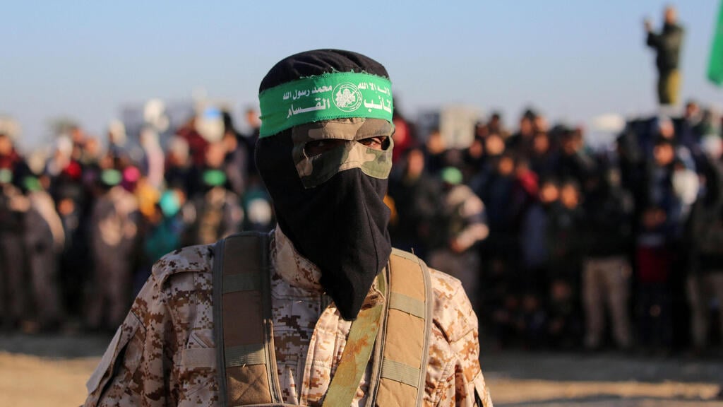 Hamas terrorist guards the handover ceremony of Israeli hostages (Photo: Bashar Taleb / AFP) הבמה בחאן יונס לקראת העברת החטופים