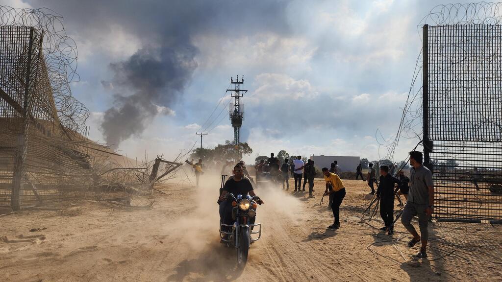 Hamas terrorists infiltrate Israel on October 7 (Photo: Hani Alshaer, AFP) חדירת הגדר והפלישה ב-7 באוקטובר