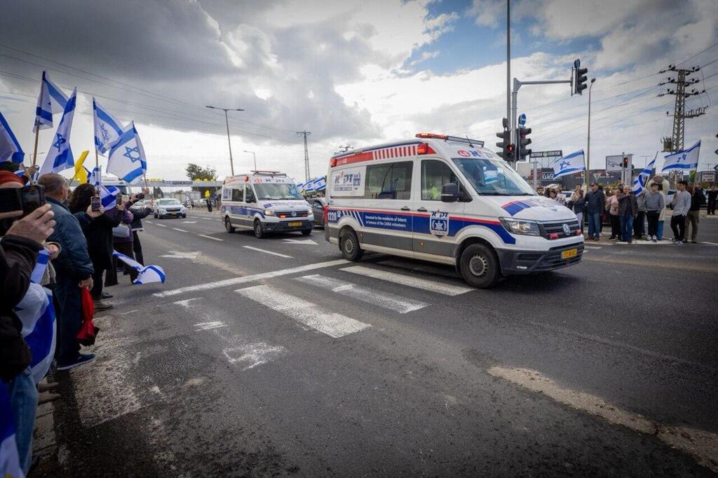 אזרחים תומכים בצומת אשקלון במהלך קבלת החטופים החללים והעברתן לאבו כביר