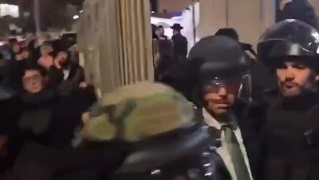 גרינברג, עם קסדה על ראשו, יוצא מהמקום חרדים קיצונים תקפו את ראש העיר בית שמש