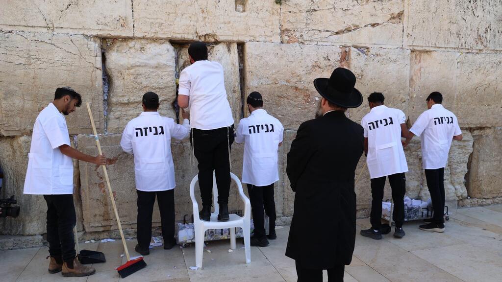 Western Wall Rabbi Shmuel Rabinowitz oversees workers clearing prayer notes at the site (Photo: The Western Wall Heritage Foundation) רב הכותל משגיח על העבודות