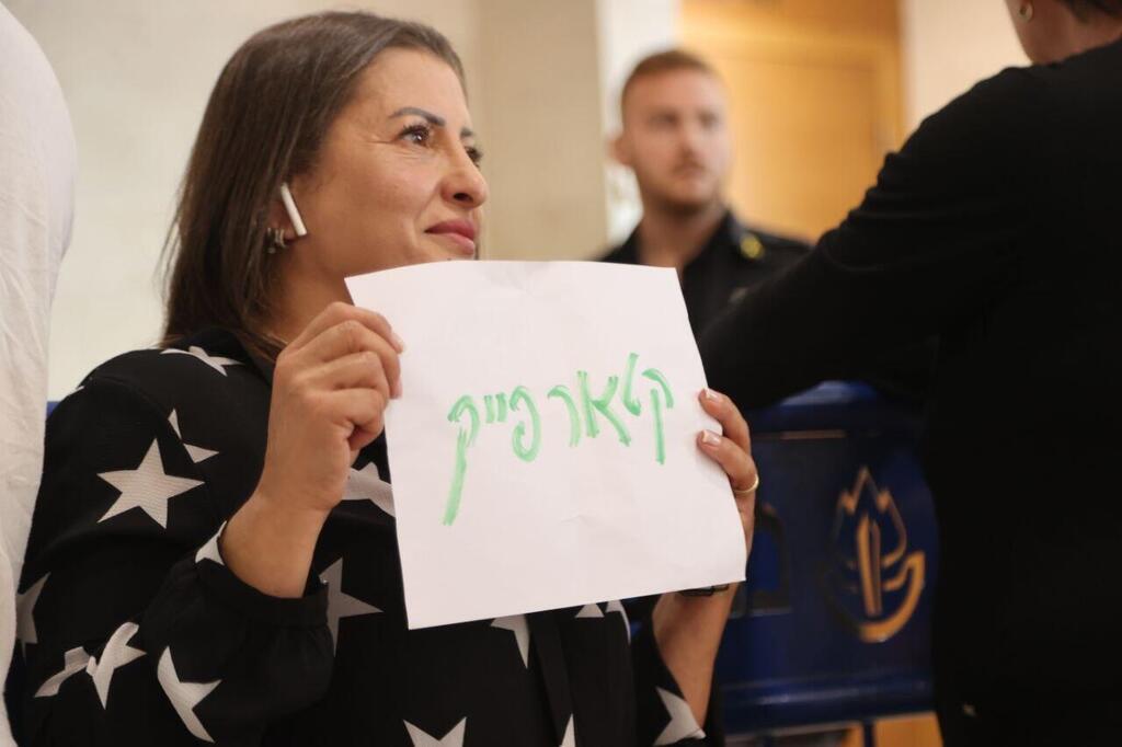 A supporter of the defendants holds up a sign reading 'Qatarfake' in court (Photo: Moti Kimchi) בית המשפט פרשת קטאר-גייט