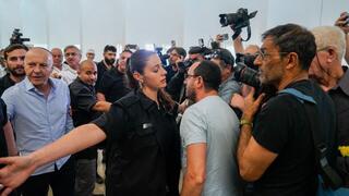 יורם כהן יוצא מהאולם בזמן שאזרחים מקיפים אותו בצעקות "בושה"