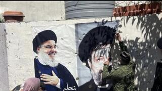 Lebanese army soldiers removing posters from Beirut featuring slain Hezbollah leaders 