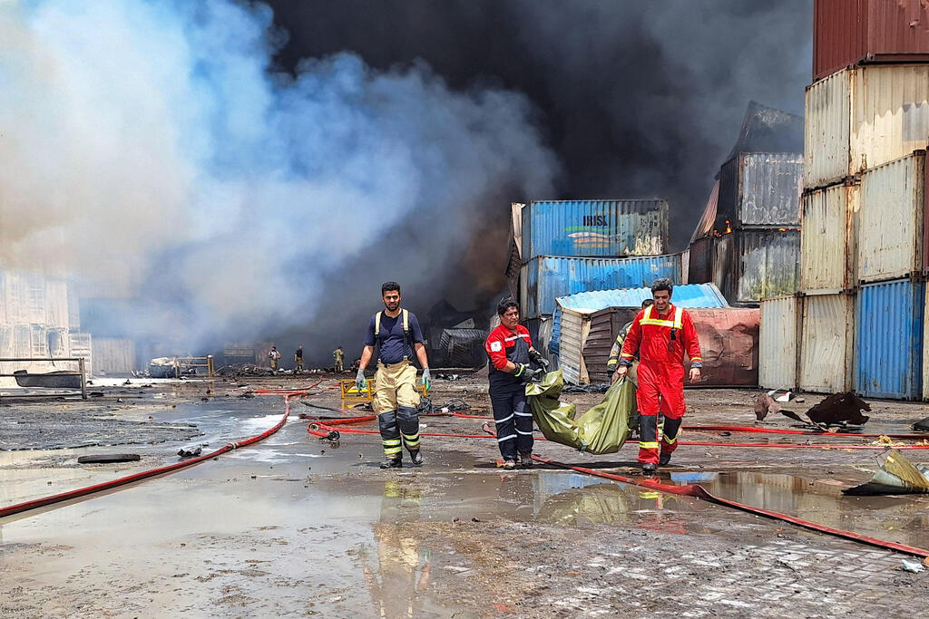 צילום: Meysam Mirsadeh / TASNIM NEWS / AFP פעולות כיבוי אש שריפה ב נמל שהיד רג'אי ב בנדר עבאס איראן אחרי פיצוץ שם