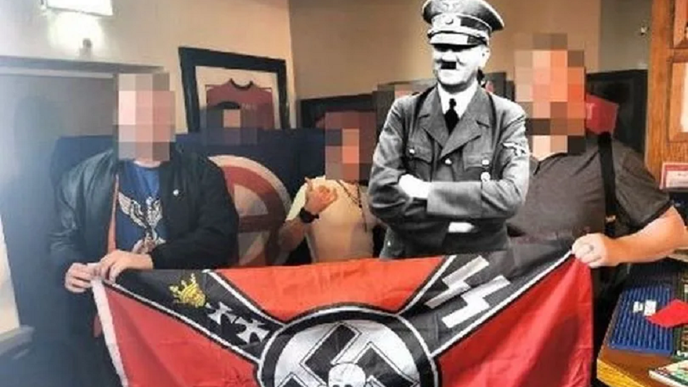 The group with Nazi flag and Hitler added digitally (Photo: British Movement) החוגגים בפאב באולדהאם, עם תמונתו של אדולף היטלר שנוספה באופן מלאכותי