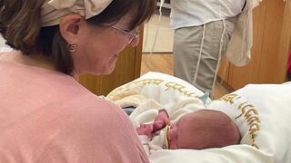 Marcy Oster holding her grandson, Adi Amichai, after the uncle he will never meet