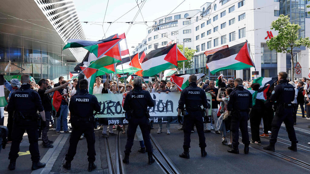 Palestinian flags wave as Eurovision contestants pass in Basel (Photo: Stefan Wermuth / AFP) דגלי פלסטין בקהל במצעד המשלחות