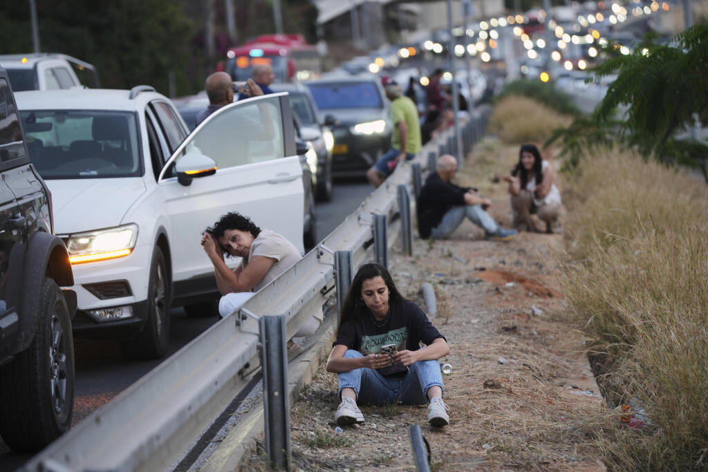 נהגים בצד הכביש בזמן אזעקה, ארכיון (צילום: AP Photo/Ohad Zwigenberg) תופסים מחסה בתל אביב