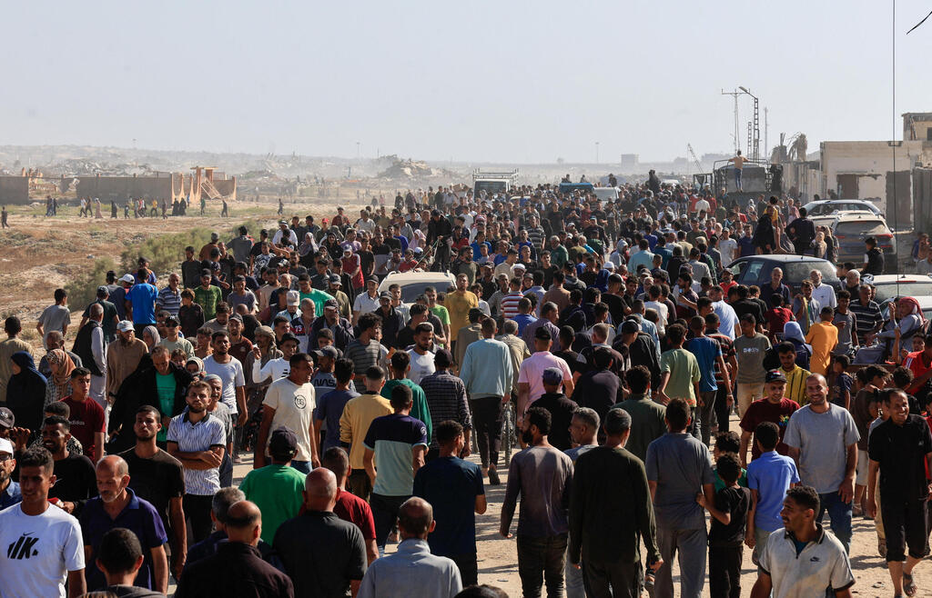 Waiting for aid in Rafah (Photo: Hatem Khaled/Reuters) עזתים הולכים לקבל חבילות סיוע המוניטרי ברפיח