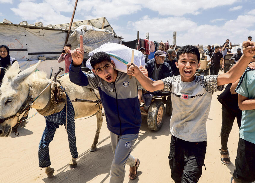 הצלחה וכישלון: מקבלים אספקה במתחם סיוע בחאן־יונס | צילום: Hatem Khaled /REUTERS yk14396435