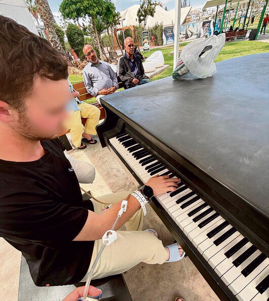 ביד אחת. א' מנגן על הפסנתר בבית החולים yk14404236