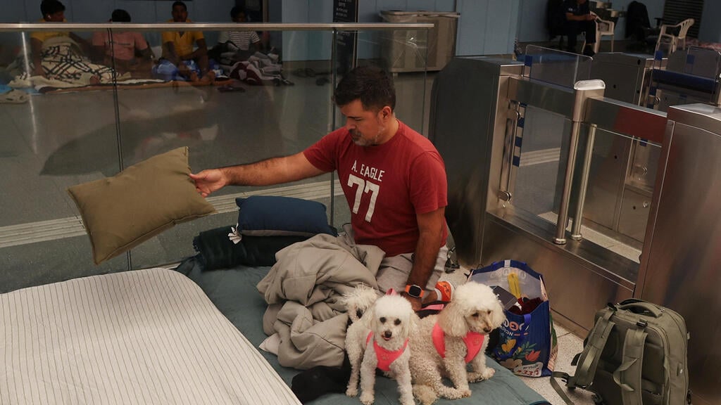 People seek shelter in Ramat Gan train station (Photo: Ronen Zvulun / Reuters) תופסים מחסה בתינת הרכבת הקלה ברמת גן
