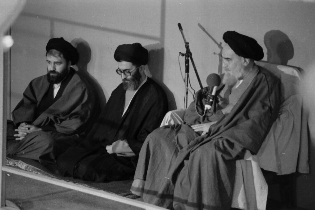 ארכיון איראן 1981 עלי חמינאי (באמצע) יושב לצד המנהיג העליון דאז רוחאללה חומייני בטקס השבעתו של חמינאי לנשיא