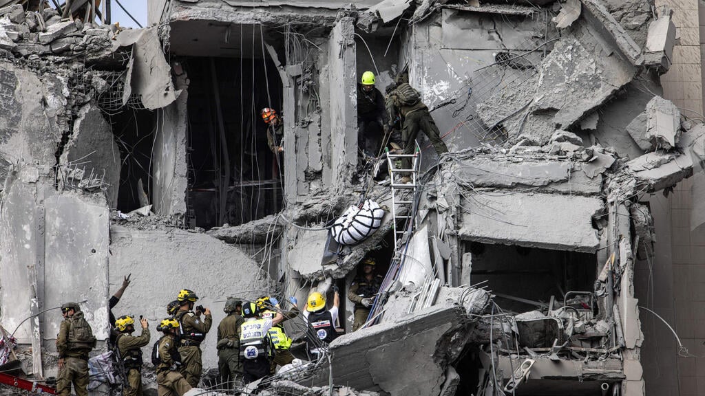 Rescue teams at Be'er Sheva impact site (Photo: John Wessels / AFP) הריסות בזירת הנפילה בבאר שבע