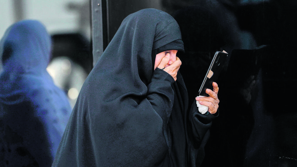 Iranian women checking phone (Photo: Ahmad Al-Rubaye/AFP) איראנית בעיר קרבלה באיראן