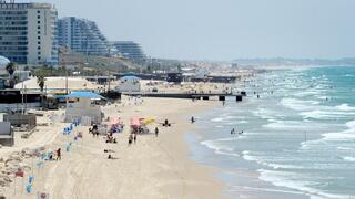 אנשים מבלים בחוף הים במהלך גל חום קיצוני