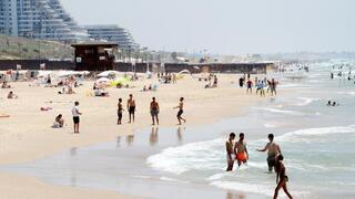 אנשים מבלים בחוף הים במהלך גל חום קיצוני
